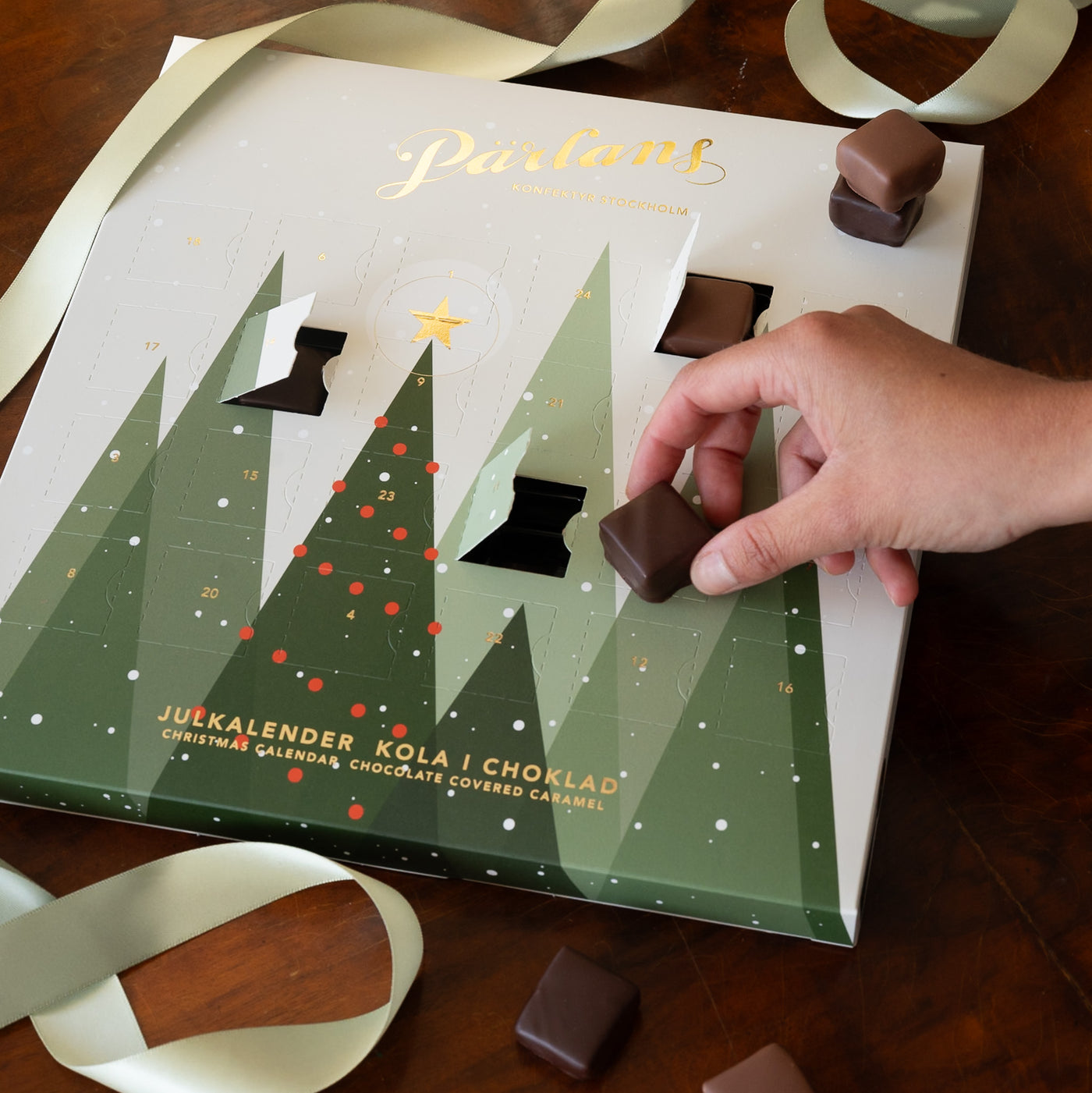 Årets julkalender med 24 olika smaker kola i ekologisk choklad från Malmö chokladfabrik. Ett hantverk från Pärlans Konfektyr i Stockholm.