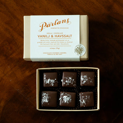 En perfekt ask med sex bitar av din favoritsmak mjuk kola i choklad, till dig eller till någon du har kär. VANILJ & HAVSSALT - silkeslen kola kryddad med varm bourbonvanilj, doppad i choklad och en nypa havssalt på toppen! Ett hantverk från Pärlans Konfektyr i Stockholm.