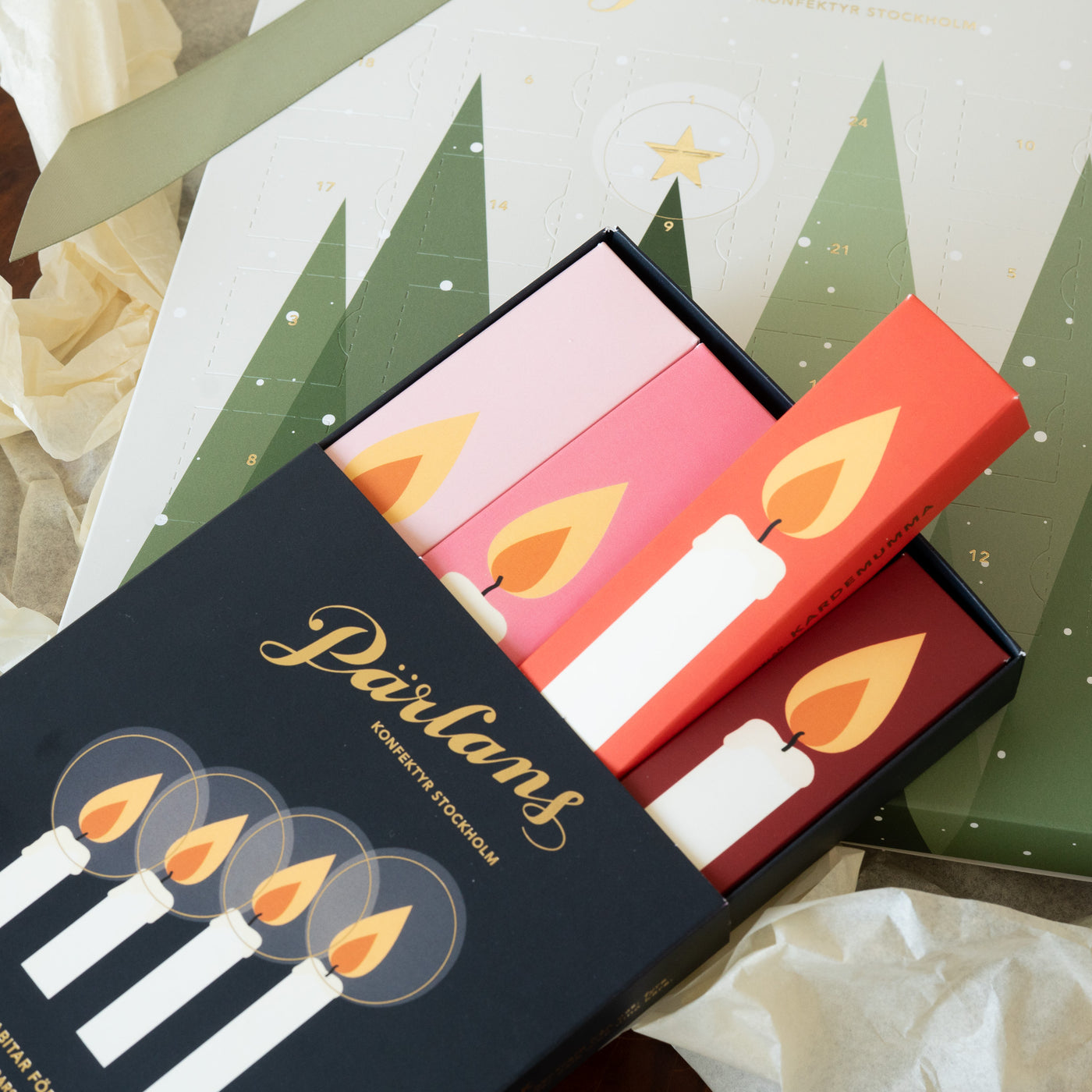 Adventskalender med kolabitar i ljus eller mörk ekologisk choklad, stor nog att dela eller unna sig själv. Ett hantverk från Pärlans Konfektyr i Stockholm.