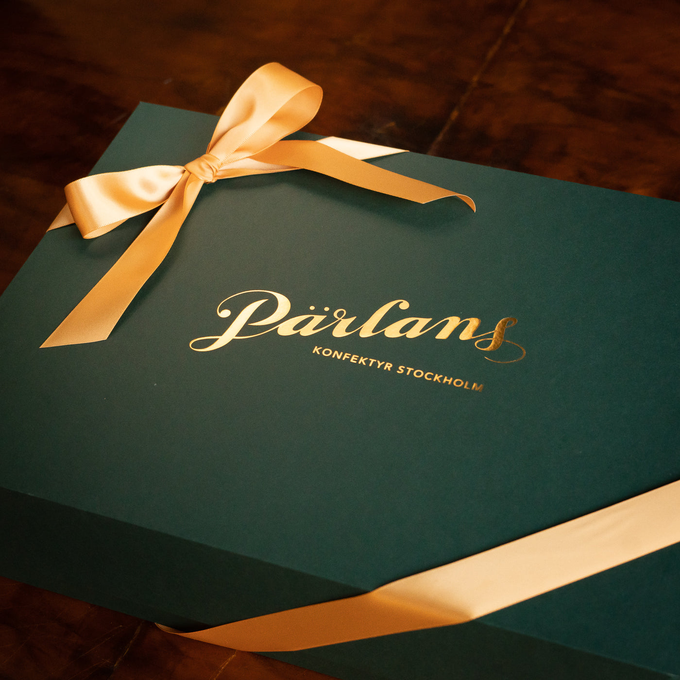 A magnificent, dark-green gift box with a festive ribbon, filled with sweets from our confectionery. From Pärlans Konfektyr in Stockholm.